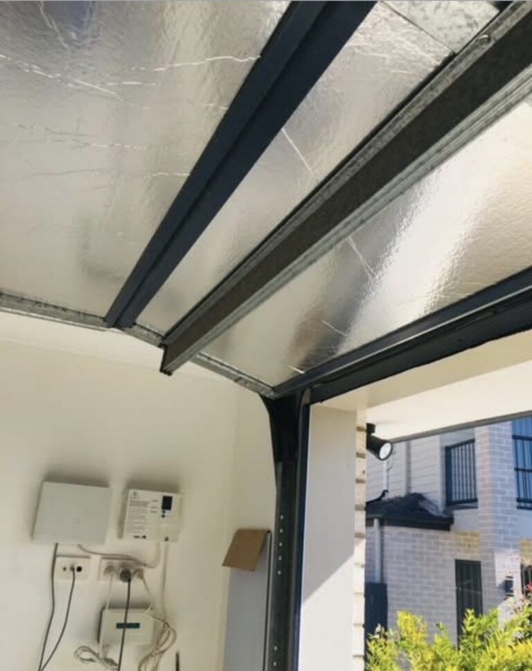 Foil insulation glued flat to metal garage door panels, removed by ThermaDoor