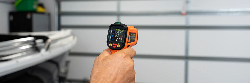 Thermal gun measuring 27.7°C on ThermaDoor insulated garage door panels